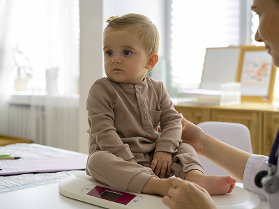 Врач детский кардиолог общается с маленьким пациентом перед плановым осмотром сердца