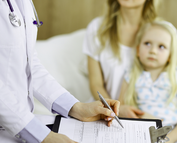 Parents and their child undergo a medical examination to enroll in kindergarten.