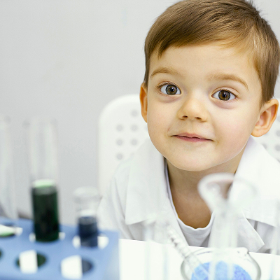 A girl at a pediatric dermatologist's appointment; the doctor uses a dermatoscope to examine her skin.