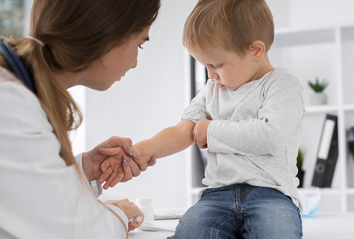 A pediatric allergist examines a child in a clinic, explaining the results of allergy tests to the parents.