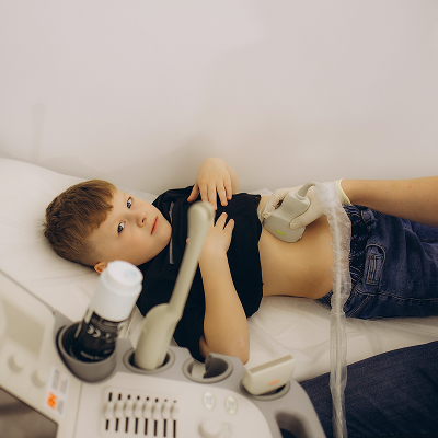 Девочка на приеме у детского врача-дерматолога, врач использует дерматоскоп для осмотра кожи.