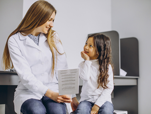An adolescent gynecologist explains the results of an examination to parents and a child.