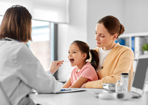 A young mother and her child at a consultation with a private pediatric ENT doctor