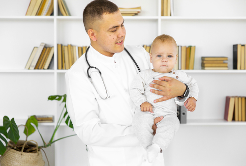 Детский хирург проводит осмотр маленького пациента в современной клинике.