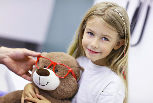 The ophthalmologist explains the results of the vision examination to the child and his mother.