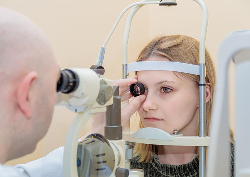 How does a Goldmann lens examination differ from other methods?